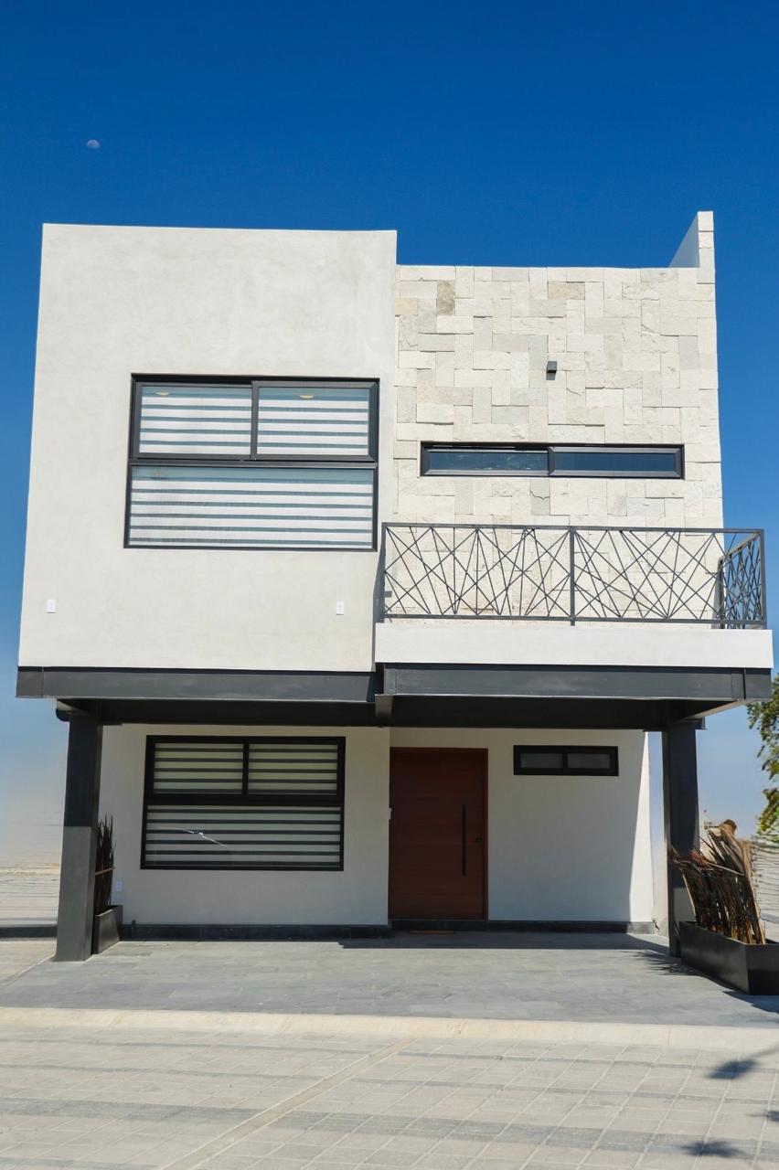 Fachada principal de casa en Villas Zacango con acabados en piedra y ventanales